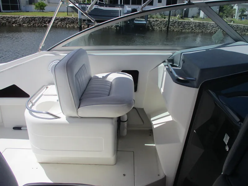 Slide: The Image of 1991 Sea Ray 350 Express Cruiser helm seat and dashboard, docked by the water. - 6