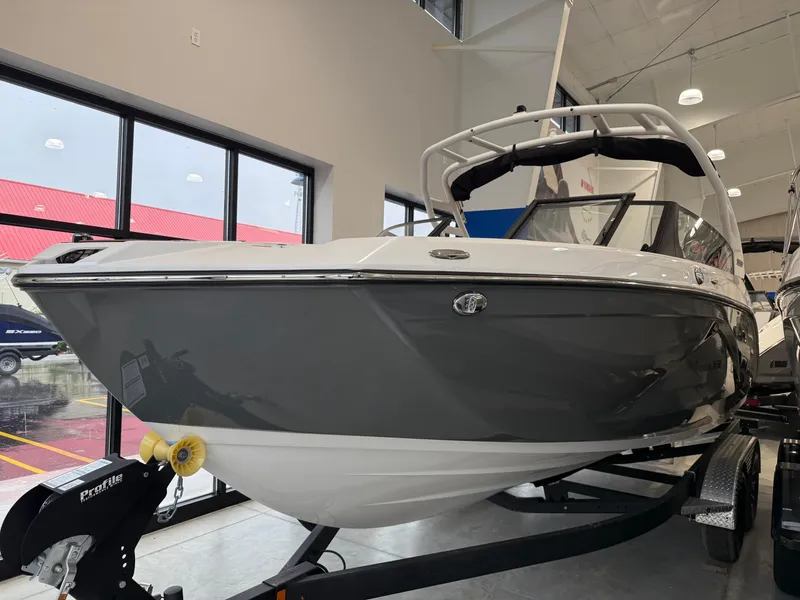 Slide: The Image of 2025 Yamaha Boats 222SD in showroom, sleek design, gray and white exterior. - 2