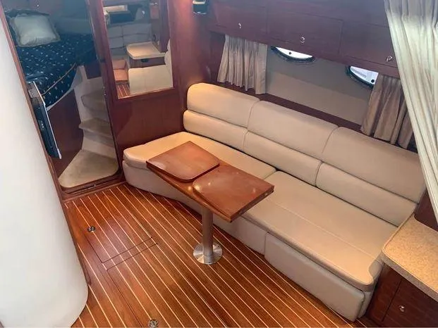 Slide: The Image of 2006 Regal Commodore 3760 IO interior with beige seating, wooden table, and elegant wood flooring. - 19