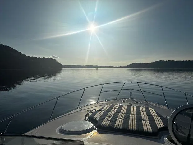 Slide: The Image of 2006 Regal Commodore 3760 IO cruising on a serene lake at sunset. - 27