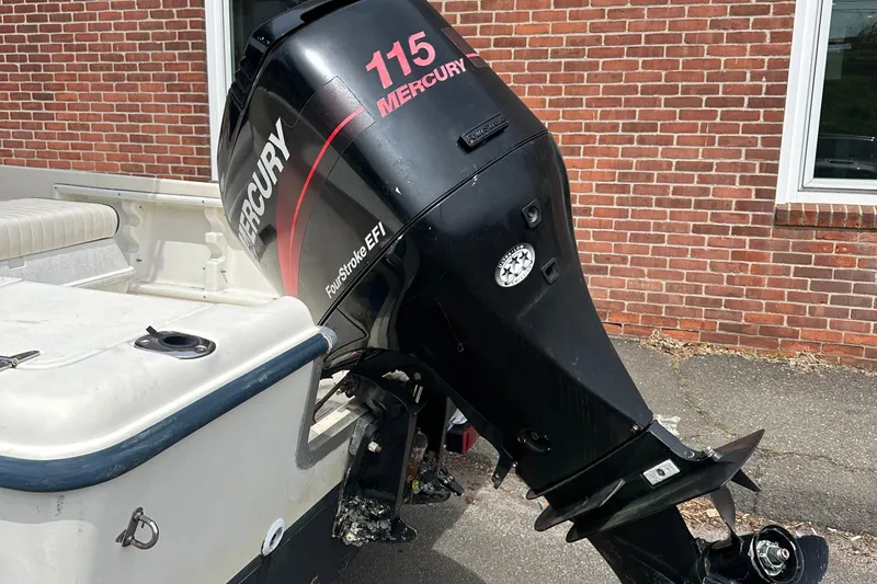 Slide: The Image of 2002 Sea Hunt 172 boat with Mercury 115 outboard motor, parked near brick wall. - 6