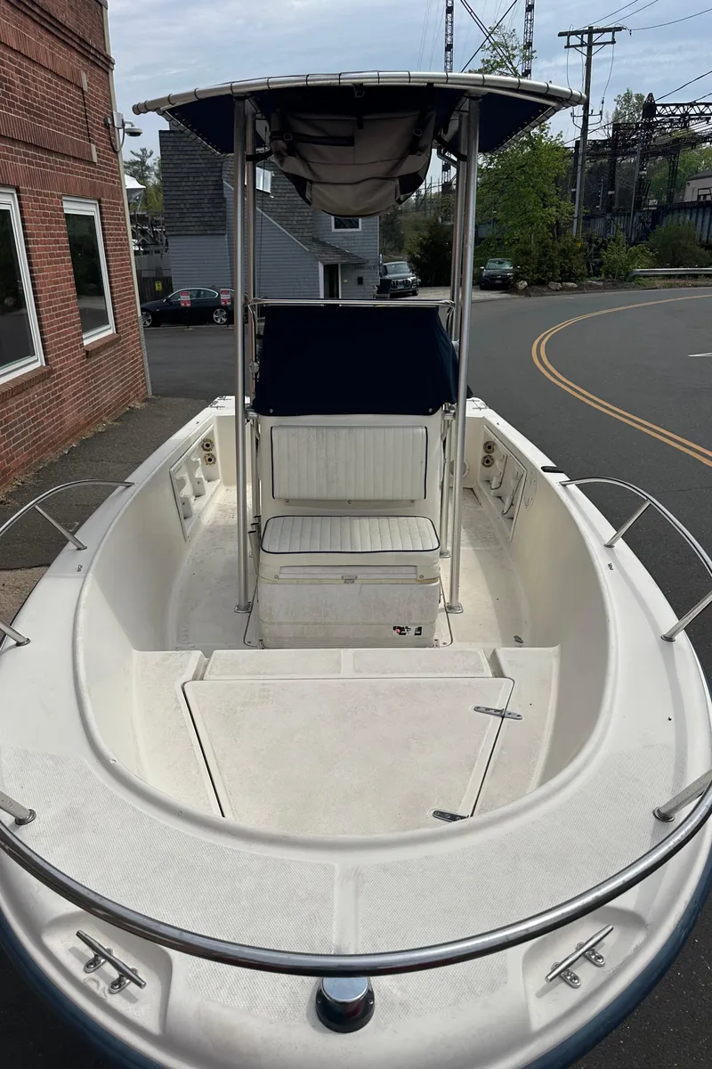 Slide: The Image of 2002 Sea Hunt 172 boat with T-top, parked on a street near brick building. - 8