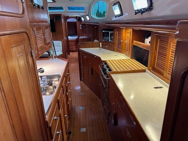 Slide: The Image of Luxurious 2014 Passport 545 Vista yacht interior with wooden cabinetry and modern kitchen amenities. - 14