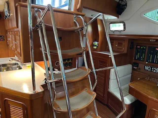 Slide: The Image of Interior of 2014 Passport 545 Vista yacht with wooden cabinetry and metal staircase. - 18