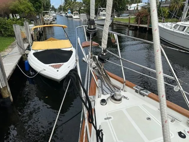 Slide: The Image of Sailboat and motorboat docked in a canal, surrounded by lush greenery. - 32