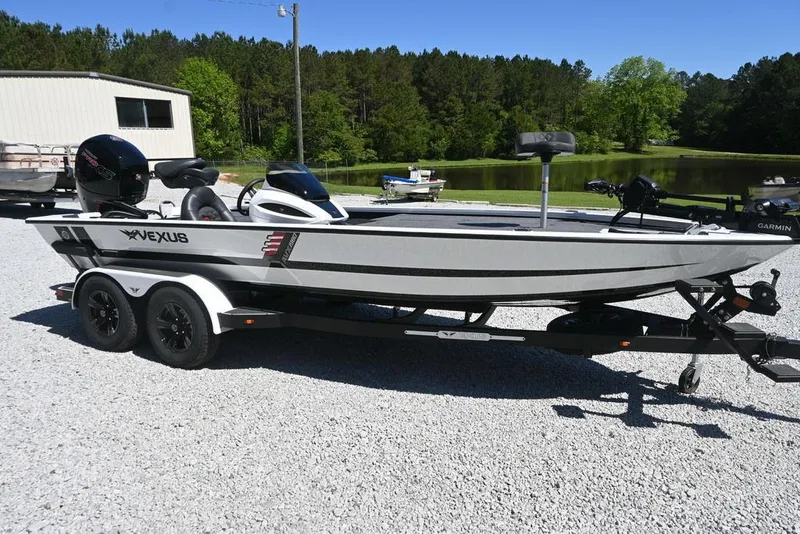 Slide: The Image of 2025 Vexus AVX 1980 boat on trailer, parked outdoors near a pond and trees. - 1