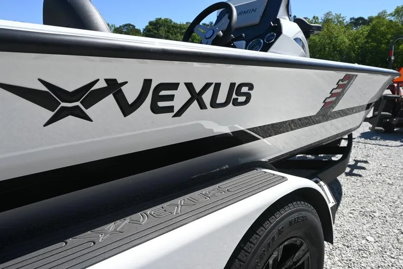 Slide: The Image of 2025 Vexus AVX 1980 boat, side view with logo, parked on gravel. - 3