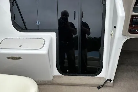 Slide: The Image of 1998 Four Winns 225 Sundowner boat interior with sliding glass door and seating area. - 15