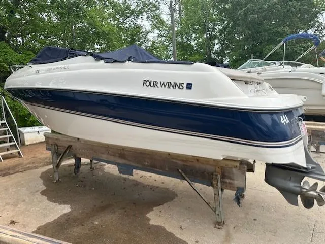 Slide: The Image of 1998 Four Winns 225 Sundowner boat on a stand, blue and white design. - 3