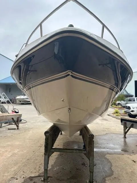 Slide: The Image of 1998 Four Winns 225 Sundowner boat on trailer, front view, in a marina setting. - 4