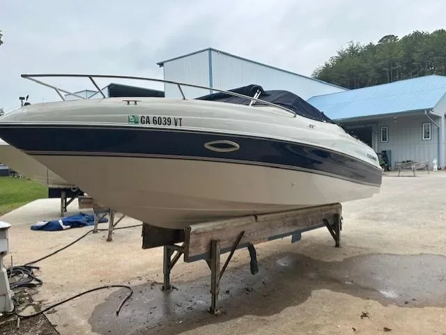 Slide: The Image of 1998 Four Winns 225 Sundowner boat on a stand, blue and white exterior. - 5