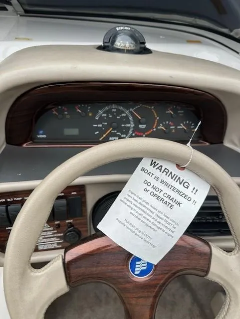 Slide: The Image of 1998 Four Winns 225 Sundowner dashboard with winterization warning tag on steering wheel. - 6