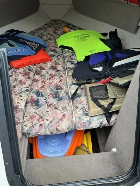 Slide: The Image of 1998 Four Winns 225 Sundowner cabin with life jackets and floral-patterned cushions. - 9
