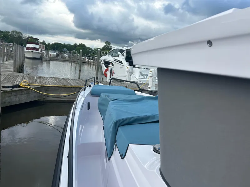 Slide: The Image of 2024 Axopar 37 XC Cross Cabin Aft Cabin docked at a marina under cloudy skies. - 4
