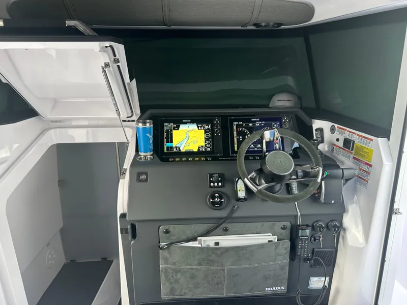 Slide: The Image of 2024 Axopar 37 XC Cross Cabin helm with navigation screens and steering wheel. - 7