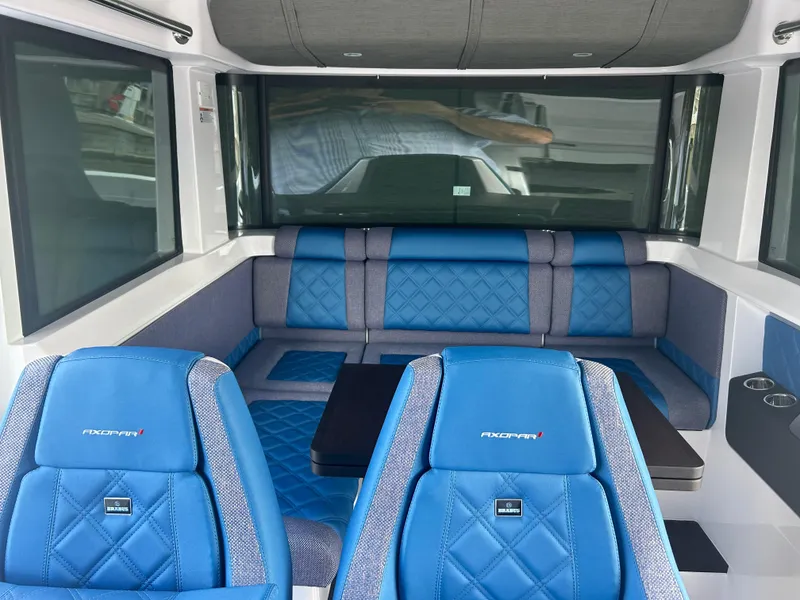Slide: The Image of 2024 Axopar 37 XC Cross Cabin interior with blue seating and modern design. - 8