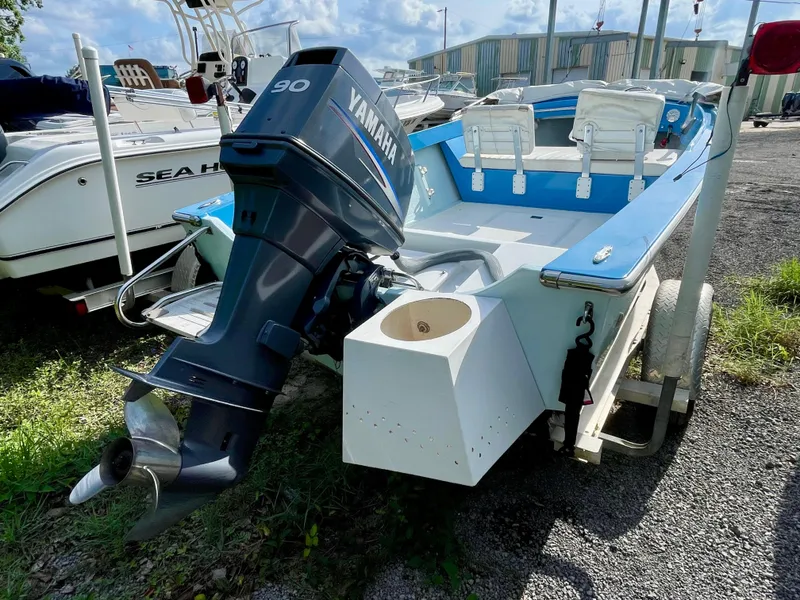 Slide: The Image of 1979 Negus 17 boat with Yamaha 90 outboard motor, parked on gravel. - 3