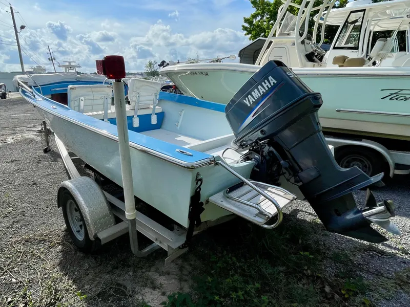 Slide: The Image of 1979 Negus 17 boat with Yamaha outboard motor on trailer, parked outdoors. - 4