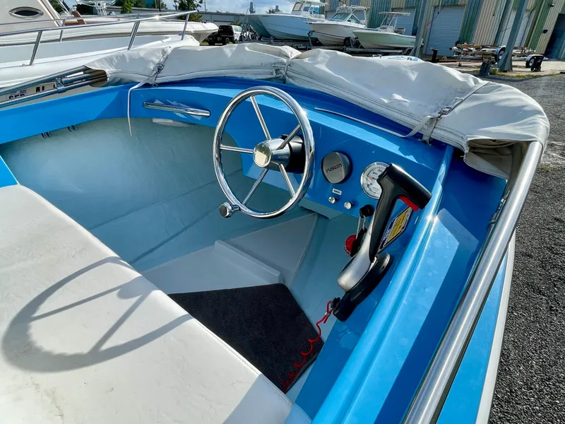 Slide: The Image of Interior of a 1979 Negus 17 boat with blue and white seating and steering wheel. - 6