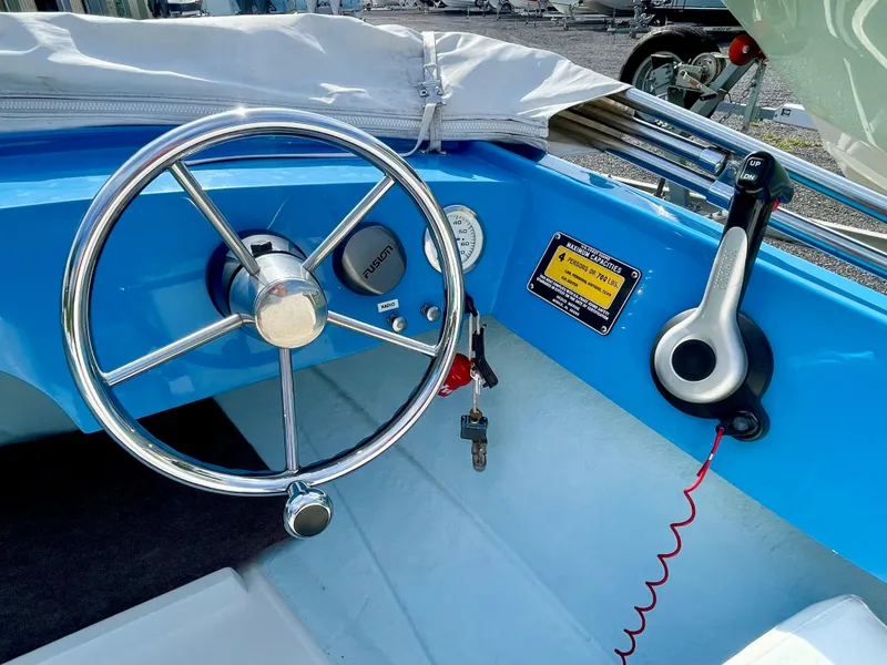 Slide: The Image of Steering wheel and controls of a 1979 Negus 17 boat, featuring a blue dashboard. - 7
