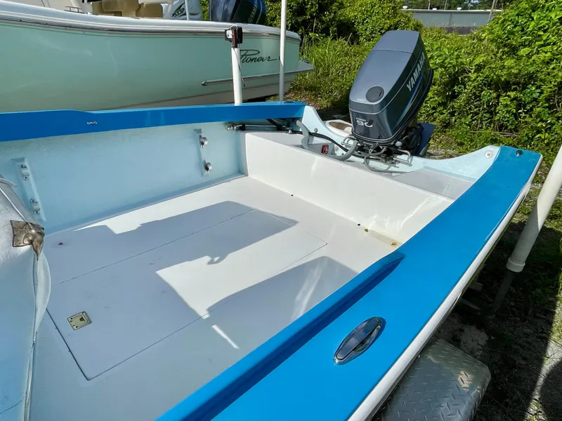 Slide: The Image of 1979 Negus 17 boat with blue trim and outboard motor, parked outdoors. - 9