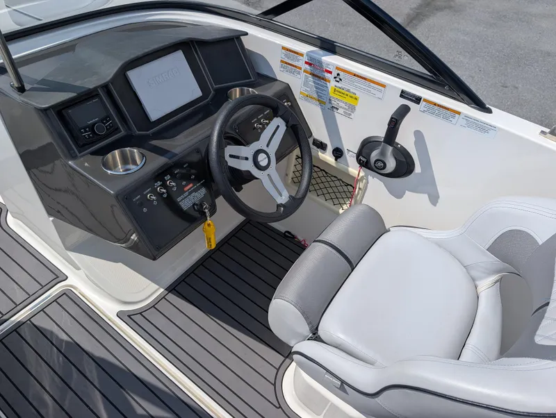 Slide: The Image of 2023 Bayliner VR5 Bowrider I/O cockpit with steering wheel, controls, and cushioned seat. - 17