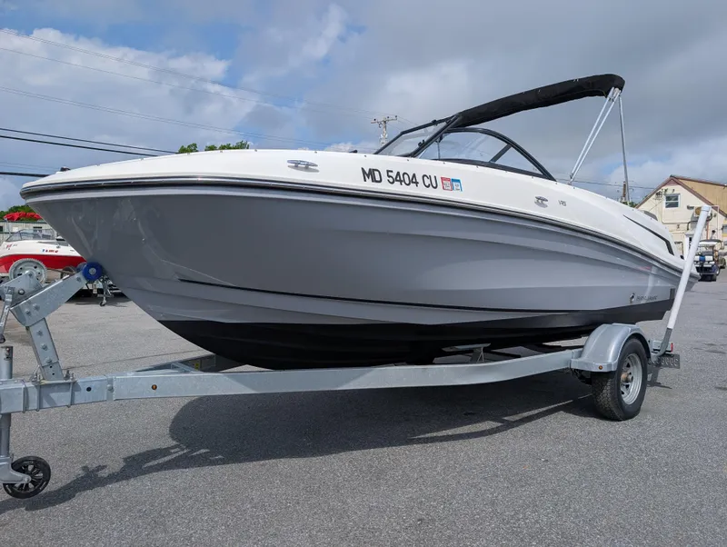 Slide: The Image of 2023 Bayliner VR5 Bowrider I/O on trailer, parked outdoors under cloudy sky. - 3
