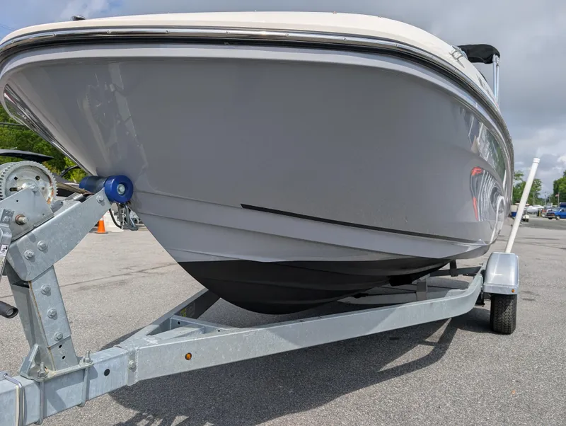 Slide: The Image of 2023 Bayliner VR5 Bowrider I/O on trailer, parked outdoors, showcasing sleek hull design. - 5