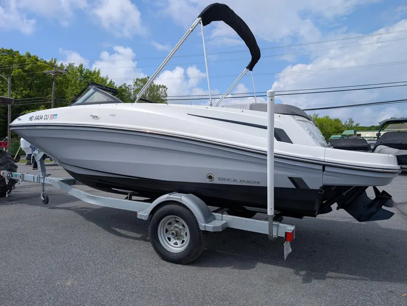 Slide: The Image of 2023 Bayliner VR5 Bowrider I/O on trailer, parked outdoors under a partly cloudy sky. - 6