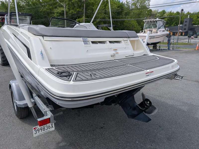 Slide: The Image of 2023 Bayliner VR5 Bowrider I/O boat on trailer, rear view, in outdoor setting. - 7