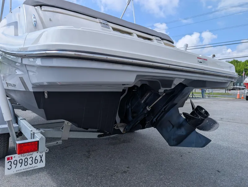Slide: The Image of 2023 Bayliner VR5 Bowrider I/O boat rear view with outboard motor and trailer. - 8