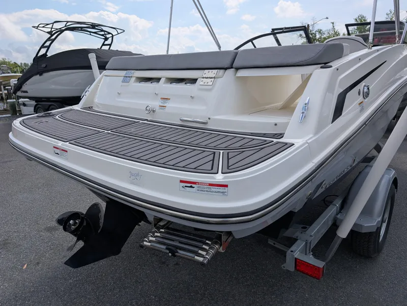 Slide: The Image of 2023 Bayliner VR5 Bowrider I/O boat, rear view, on trailer, showcasing swim platform. - 9