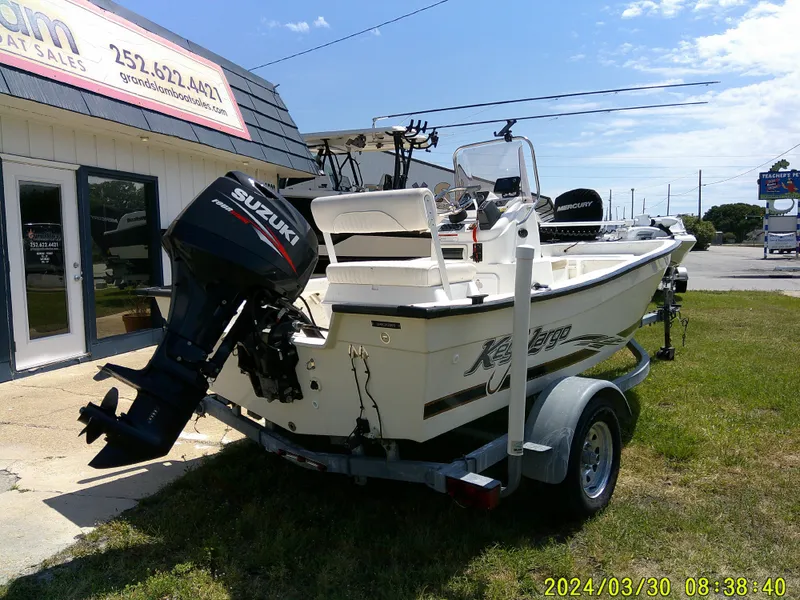 Slide: The Image of 2016 Key Largo 160 CC boat with Suzuki outboard motor on a trailer, parked outside a sales building. - 4