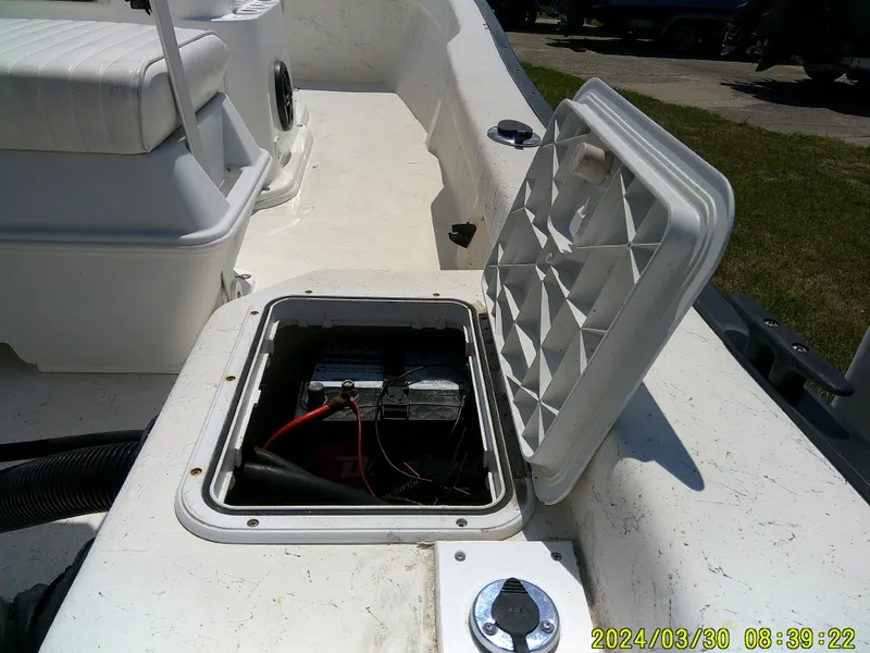 Slide: The Image of 2016 Key Largo 160 CC boat battery compartment with open hatch, showing wiring and components. - 7