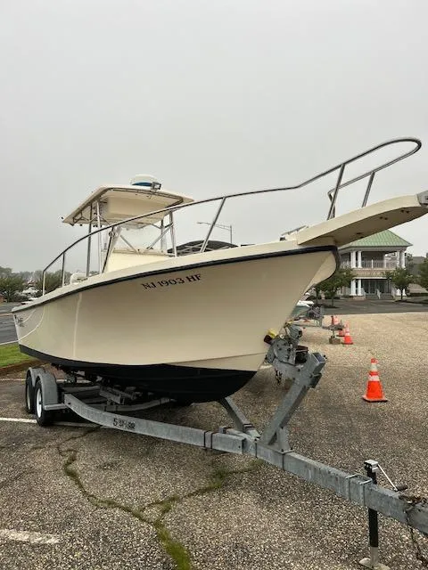 The Image of 1996 Parker 2300 DV Center Console boat on trailer in parking lot. - 1