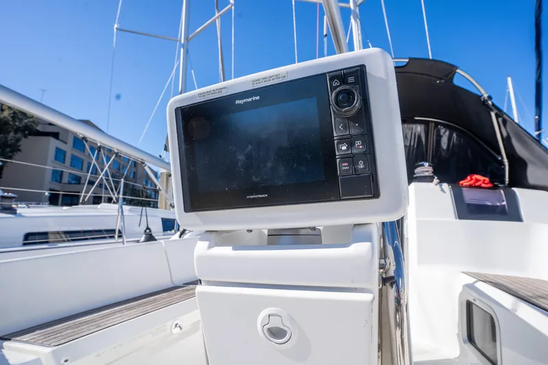 Slide: The Image of Cockpit of 2020 Jeanneau Sun Odyssey 389 with navigation display, marina background. - 10