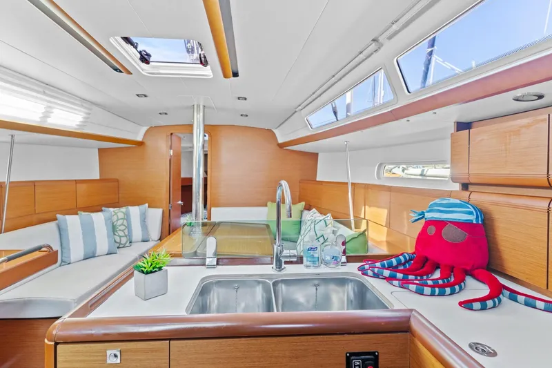 Slide: The Image of Interior of 2020 Jeanneau Sun Odyssey 389 yacht with modern kitchen and seating area. - 11