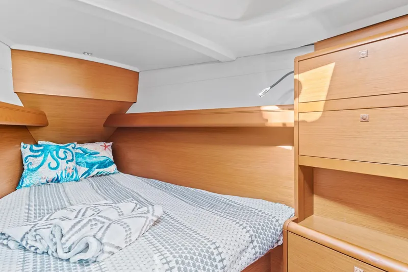 Slide: The Image of Cozy cabin interior of 2020 Jeanneau Sun Odyssey 389 with bed and wooden storage. - 13