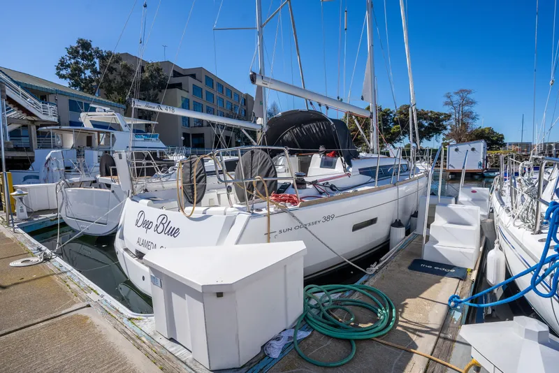 Slide: The Image of 2020 Jeanneau Sun Odyssey 389 sailboat docked at marina under clear blue sky. - 5