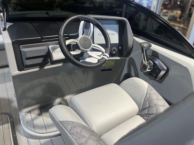 Slide: The Image of 2024 Manitou LX 23 RFXW boat cockpit with Garmin display and luxury seating. - 6