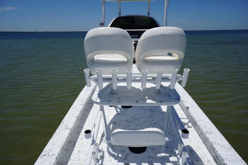 Slide: The Image of 2019 Haynie 23 Super Cat boat with dual seats and rod holders on calm water. - 12