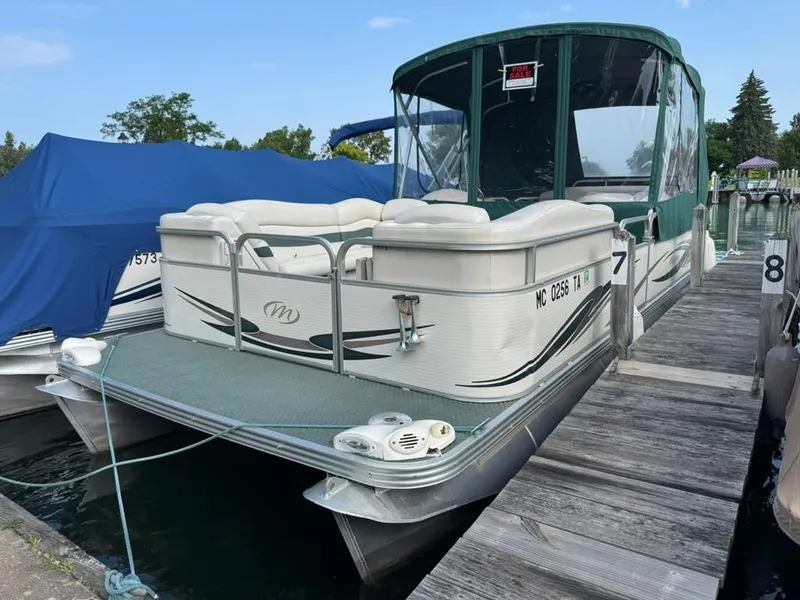 Slide: The Image of 2007 Manitou Legacy pontoon boat docked, green canopy, for sale sign visible. - 0