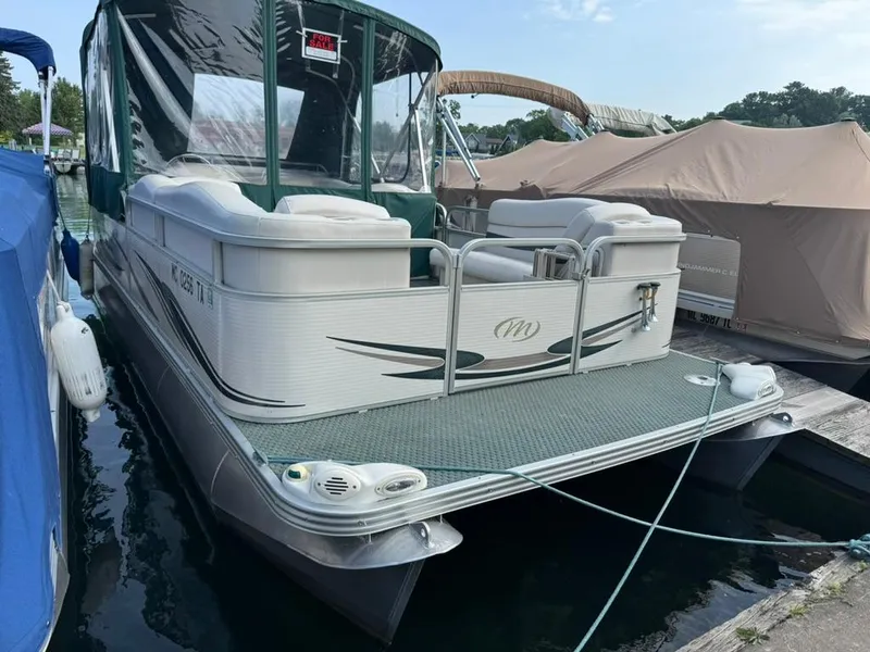Slide: The Image of 2007 Manitou Legacy pontoon boat docked, featuring a "For Sale" sign and covered seating area. - 1