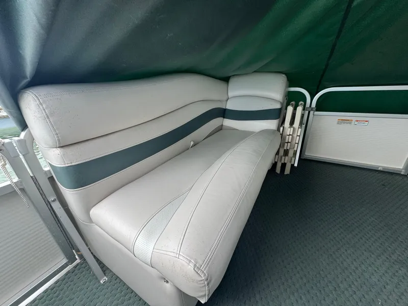 Slide: The Image of 2007 Manitou Legacy boat interior with gray seating and green accents. - 11