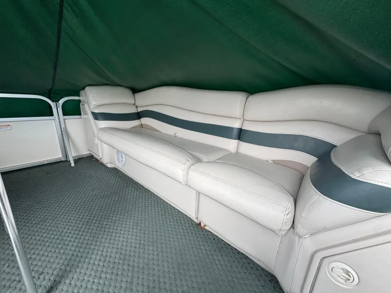 Slide: The Image of 2007 Manitou Legacy boat interior with cushioned seating and green canopy. - 12