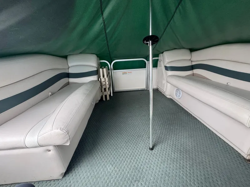 Slide: The Image of 2007 Manitou Legacy boat interior with green canopy and cushioned seating. - 13