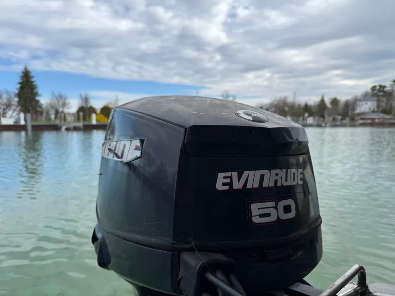 Slide: The Image of Evinrude 50 outboard motor on a 2007 Manitou Legacy boat, lake view. - 16