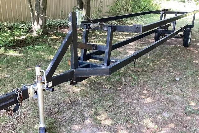 Slide: The Image of 2007 Manitou Legacy trailer on grass, featuring sturdy metal frame and single axle. - 17