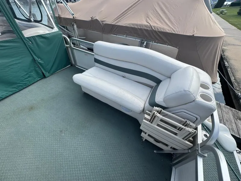 Slide: The Image of 2007 Manitou Legacy boat interior with white seating and green accents. - 3