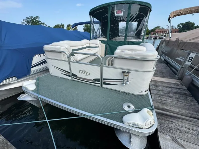 Slide: The Image of 2007 Manitou Legacy pontoon boat docked, featuring white seating and green canopy. - 4